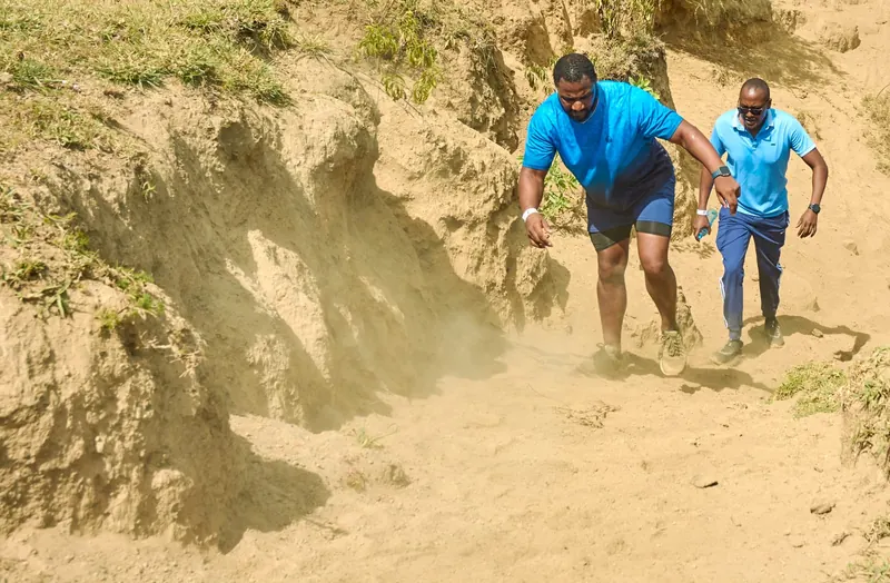 Runners climbing a steep sandy trail during an Ibiza Fun Run event